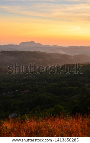 Sunset over the valley and its village in the Carpathian mountains