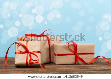 Festive gift box on blue bokeh background. Festive greeting card.