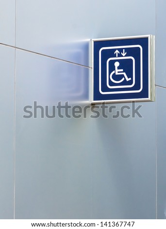 Blue Handicap Elevator Sign on Metallic Wall with Left and Below Copy space