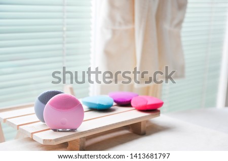 Couple of skin care silicone brushes in small on wooden table. Brushes for skin treatments. Cosmetic procedure. First step, skin cleaning. Peeling and gently rubbing face. Copy space, design space.