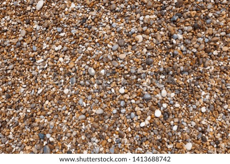 A pile of wet sea colored stones of different shapes on the beach on a wild beach in Gargano, Italy. Natural backgound, free space for text, close-up