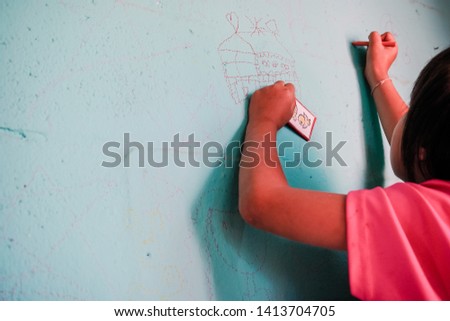  Girl painting on the wall in a workshop.