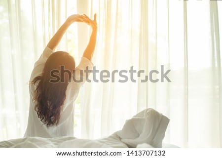 Asian woman get up stretching  relax in bed room at home, early out morning and wake up rest sunny day.  Lifestyle Concept  Royalty-Free Stock Photo #1413707132