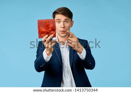 Business man in a suit with a gift in the hands of a corporate holiday luxury