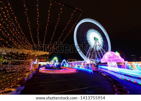 Blur rotate moving of Ferris wheel with lighting at carnival park in night time 