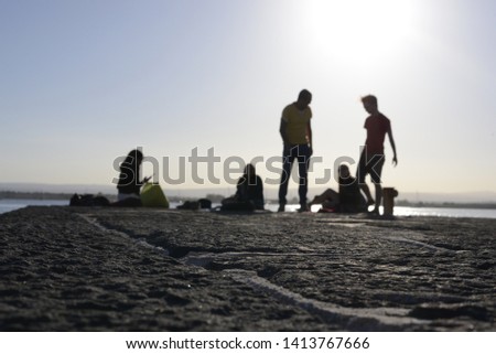 Bokeh picture of talking people on a pier in Sicily