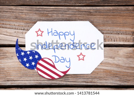 Text Happy Independence Day with paper mustache on brown wooden table