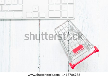 shopping cart and keypad on white wood table,top view