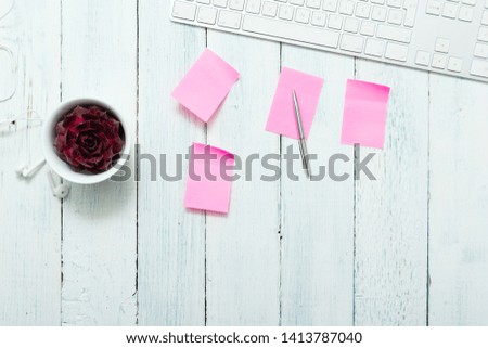 work place with pink post its and succulent plant, top view
