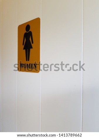 Public toilet signs for women in front of the white door