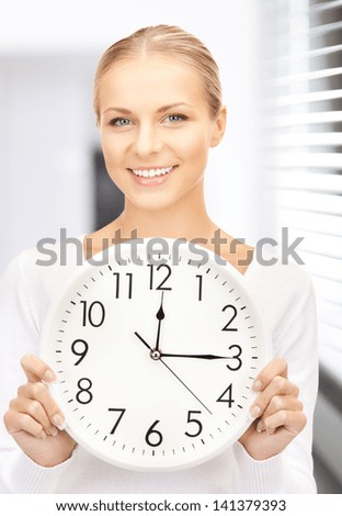 picture of attractive businesswoman with wall clock