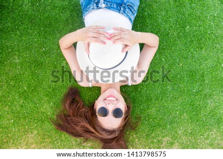 Beautiful woman is laying down on green 