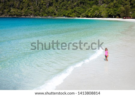 Child playing on tropical beach. Kids on exotic island. Sea and ocean fun. Family summer vacation in luxury resort. Travel with young kid. Children swim. Swimming and sun protection wear.