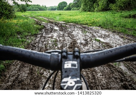 Riding a bike through the mud. Mountain Biker Riding Through A Dirty Puddle Royalty-Free Stock Photo #1413825320