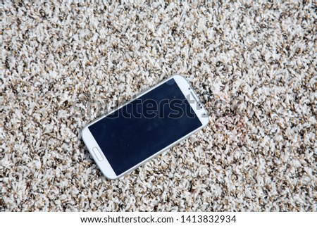 generic cell phone. cell phone on a carpet. blank screen with room for text or images. 

