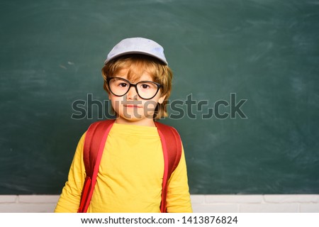 Cute boy with happy face expression near desk with school supplies. Home schooling. School kids. Learning concept.