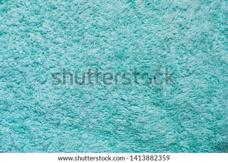 Absorbent turquoise towel fabric close-up texture. Soft cotton fabric towel texture. Detail of the turquoise bath towel texture