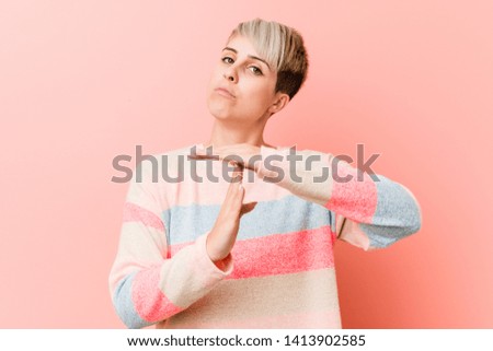 Young natural curvy woman showing a timeout gesture.
