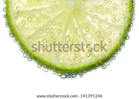 Lime Slice in Clear Fizzy Water Bubble Background Isolated Royalty-Free Stock Photo #141391246