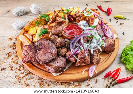 Closeup view on set of grilled vegetables and meat served on wooden serving board on the table with herbs spices. Barbecue pork, beef and chicken, mushroom and potatoe. Copy space. Picture for menu