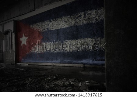 painted flag of cuba on the dirty old wall in an abandoned ruined house. concept