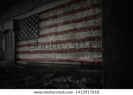 painted flag of united states of america on the dirty old wall in an abandoned ruined house. concept
