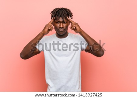 Young african black man focused on a task, keeping him forefingers pointing head.