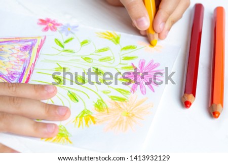 The child draws flowers for mom with pencils. Baby gift.