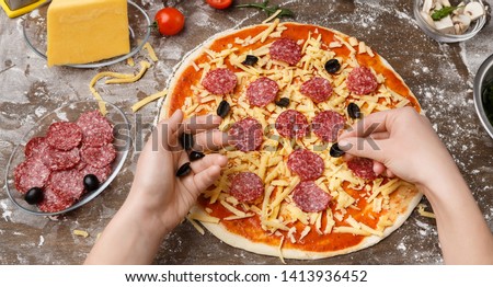 Pizzaiolo Adding Black Olives To Pizza, Preparing Pepperoni Pizza In Restaurant