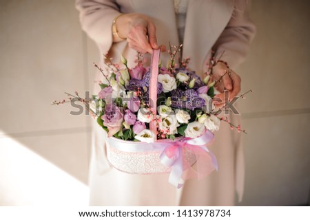 Small beautiful bouquet of various flowers in little light purple basket
