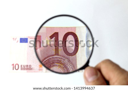 Fragment of a paper banknote. View through a magnifying glass.