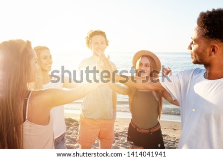 Friends raising their hands on the beach