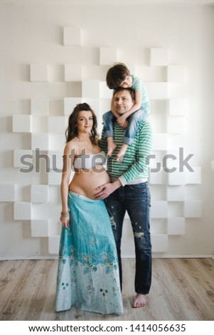 Happy family waiting for a second child. Last months of pregnancy. Pregnant woman with husband and little boy . Second pregnancy, maternity concept.