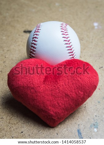 Baseball ball with a red heart on a wooden surface