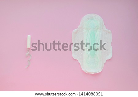 Tampon and feminine gasket on a pink background. soft focus. copy space.