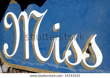 Blue sign with the word "Miss" in cursive written on it.