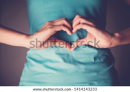 Woman hands making a heart shape on her stomach, healthy bowel degestion, probiotics and prebotics  for gut health, organ donor day Royalty-Free Stock Photo #1414143233