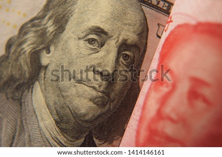 Dollar notes of the US and Chinese yuan rested against each other depicting a confrontation between two economic and political systems. Dollar. Yuan. Money.                                            