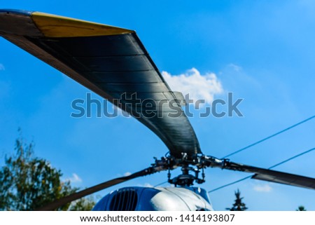 Closeup of helicopter rotor against blue sky