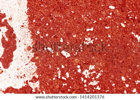 Old asphalt surface painted with white paint red color toned close up. Abstract background 