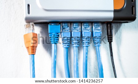 Blue internet connection cable 
5 lines  plug in the hub have one line, Its orange head Not plugged in. Royalty-Free Stock Photo #1414236257