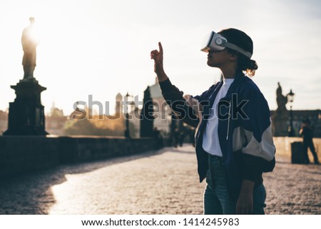 Woman in silhouette wearing vr headset augmented virtual reality in history city center. Concept of virtual museum Royalty-Free Stock Photo #1414245983