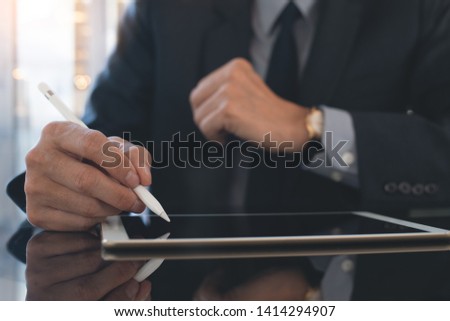 Electronic signature, Business technology concept. Businessman, executive manager using digital tablet signing electronic document, business contract with digital pen on desk in modern office, closeup