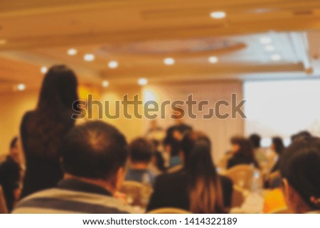 Blurred photo of the audience and speaker in seminar meeting in the hall