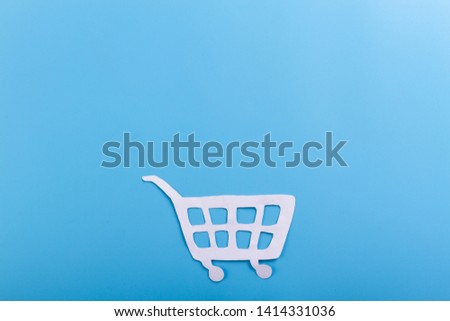 shopping trolley on blue background with copy space