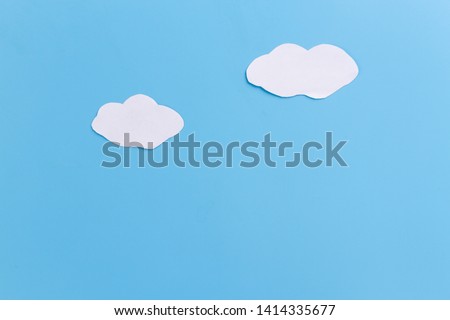 white clouds painted on blue bacground. paper cut