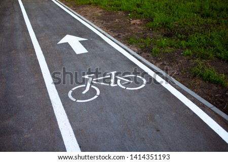 Bike path. Sign white paint on the pavement. Summer. bicycle traffic sign painted on the floor