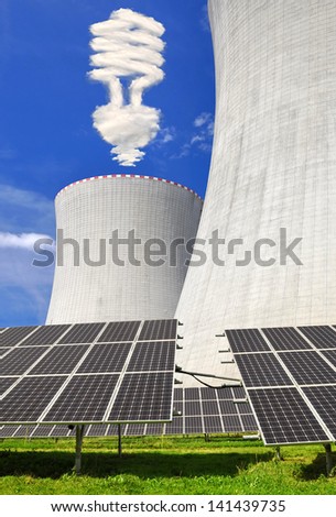 Solar energy panels before a nuclear power plant and bulb from clouds