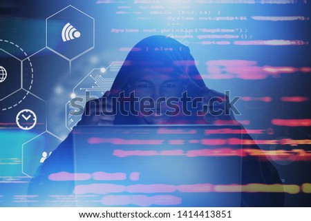 Serious African American hacker in hoodie looking at laptop. Double exposure of online security interface and blurred lines of code. Toned image