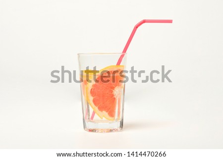 A glass of grapefruit cocktail on a white background